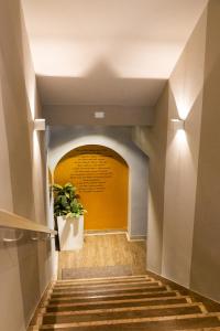 un corridoio che conduce a un tunnel con una porta gialla di Albergo Leon D'Oro a Maniago