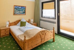 a bedroom with a wooden bed and a window at Spreewaldhotel Garni Raddusch in Vetschau