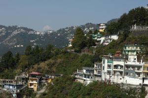 a group of houses on a hill with trees at Shining Hills in Mussoorie