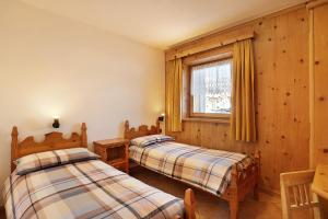 a bedroom with two beds and a window at Baita sulle Alpi in Livigno
