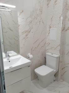 a white bathroom with a toilet and a sink at Апартамент BOHO CHIC 2 Free parking in Varna City