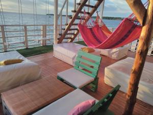 a hammock and a chair on a boat at posada donde Uriel Playa tranquila in Baru