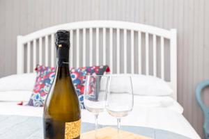a bottle of wine and two glasses on a table at Little Gem in Swanage