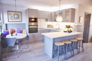 a kitchen with a island with bar stools at SEALOFT Aldeburgh Air Manage Suffolk in Aldeburgh