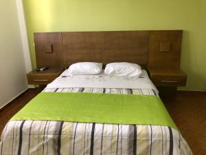 um quarto com uma cama grande e 2 mesas de cabeceira em Figaro Hotel Samana em Santa Bárbara de Samaná