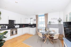 a kitchen and dining room with a table and chairs at Little Gem in Swanage
