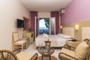 een hotelkamer met een bed en een woonkamer bij Porto Koukla Beach in Lithakia