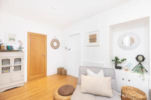 a living room with a couch and a wooden floor at Little Gem in Swanage