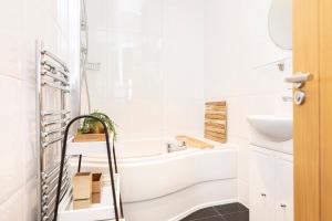 a white bathroom with a tub and a sink at Little Gem in Swanage +24 photos