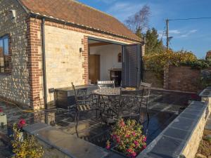 a patio with a table and chairs and a building at The Annex at Church View Barn in Snitterby