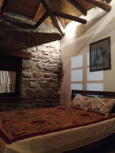 sypialnia z łóżkiem i kamienną ścianą w obiekcie Παραδοσιακή πέτρινη κατοικία στην Βλάχα Ελάτης w mieście Vlácha