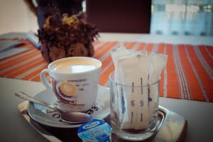 a cup of coffee and a glass of milk on a tray at Casa Brâncușiana in Târgu Jiu +45 photos