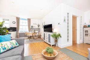 a living room with a couch and a tv at Little Gem in Swanage