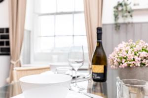 a bottle of wine and two glasses on a table at Little Gem in Swanage
