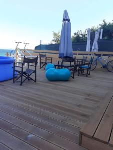 a group of chairs and an umbrella on a deck at Beach House Cabacum in Golden Sands