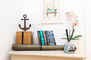 a shelf with books and a clock on it at Little Gem in Swanage