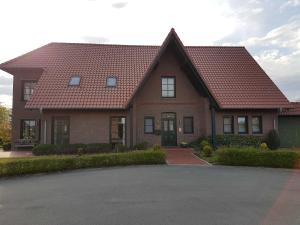a brick house with a red roof at Ferienwohnungen Haus Elena 45241 in Ditzum