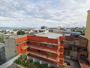 an orange building on top of a city at Avida Davao by davaobnb & Lemonique Homes in Davao City