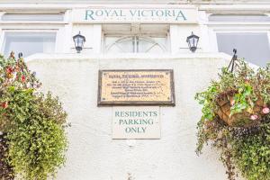 a sign on the side of a building with plants at Little Gem in Swanage