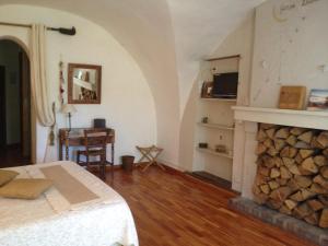 a bedroom with a fireplace and a bed and a table at La Pastorale in La Bâtie-Neuve