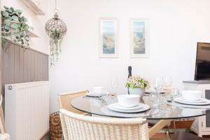 a dining room with a glass table and chairs at Little Gem in Swanage