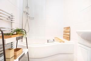 a white bathroom with a tub and a sink at Little Gem in Swanage