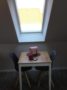 einen Tisch mit einem Fenster und einem rosa Objekt darauf in der Unterkunft Apartment Marit in Norden