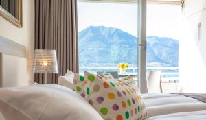 una camera da letto con finestra affacciata su una montagna di Smart-HOTEL MINUSIO, a Swiss Quality Hotel a Locarno