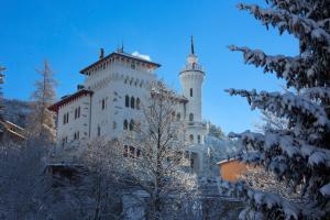 a tall white building with a tower in the snow at Résidence Château des Magnans by Nevesol in Jausiers