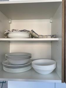 a white cabinet with plates and bowls in it at nJoy! EXPO Studio & Zentral - Stuttgart Flughafen & Messe - perfekt für Work & Travel in Filderstadt