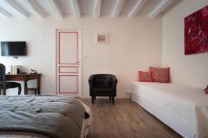 1 dormitorio con cama, silla y escritorio en Le Clos de La Rousselière B and B, en Francueil