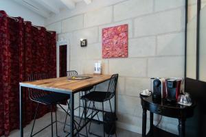 フランキュイユにあるLe Clos de La Rousselière B and Bのテーブルと椅子が備わる壁の客室です。