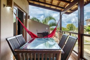 uma mesa e cadeiras numa varanda com rede de descanso em TRIPLEX V7 Pipa Beleza Spa Resort Piscina privada,Jacuzzi e hidromassagem em suíte! em Pipa