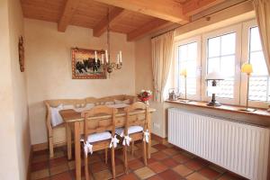 una sala da pranzo con tavolo e alcune finestre di Weitblick a Tinnum