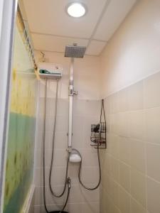 een badkamer met een douche met een douchekop bij Evelyn's Place at Tagaytay 2 in Tagaytay