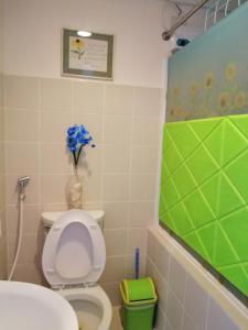 La salle de bains est pourvue de toilettes et d'un vase de fleurs. dans l'établissement Evelyn's Place at Tagaytay 2, à Tagaytay