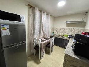 a small kitchen with a small table and a refrigerator at Tenexia - Mountain View in La Gaulette