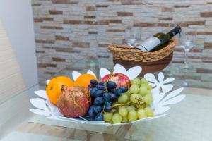 a plate of fruit on a table with a bottle of wine at Apartman Neve in Dubrovnik