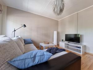 uma sala de estar com um sofá e uma televisão de ecrã plano em R63 Apartment with Terrace em Tartu