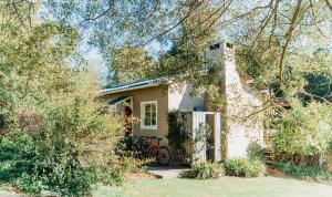 Oakhurst Farm Cottages في وايلدرنيس: منزل صغير مع دراجة متوقفة أمامه