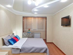 een slaapkamer met een bed met blauwe en rode kussens bij Уютная квартира класса ЛЮКС в городе Тараз in Taraz
