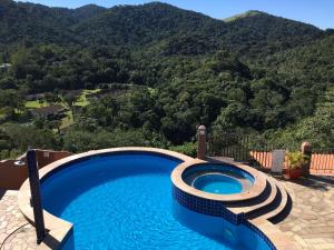 a swimming pool with a view of the mountains at Pousada Santa Fe de Penedo in Penedo