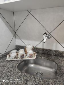a kitchen sink with a tray with tea pots and pans at Pousada Brisamar Morro dos Conventos in Conventos +179 photos