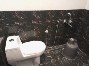 哥印拜陀的住宿－Purple Inn，一间带卫生间和黑色大理石墙的浴室