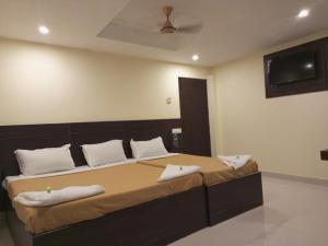 哥印拜陀的住宿－Purple Inn，一间卧室配有一张大床和毛巾