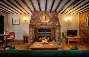 a living room with a brick fireplace with a table at The Farmhouse at Fincham in Fincham