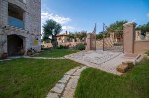a house with a yard with a gate and a stone pathway at Villa Olga in Kalamaki