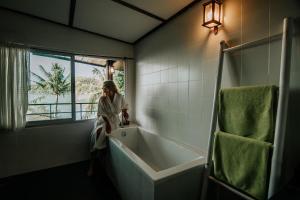 a woman sitting on a bath tub in a bathroom at Cookies Salad Resort in Salad Beach
