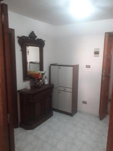 a room with a mirror and a dresser and a refrigerator at Casa Agatina in Catania