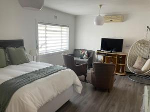 1 dormitorio con 1 cama, sillas y TV en Phantom view en Alberton